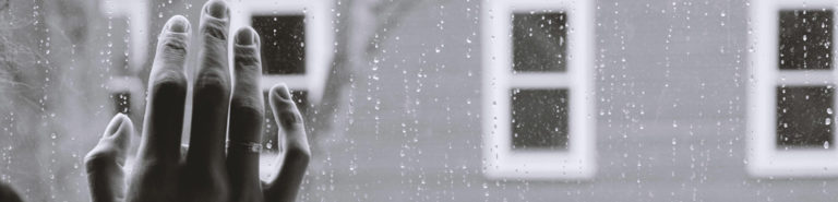 Image of a hands and a rain-streaked window